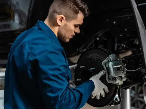 A mechanic fitting a brake disc and caliper